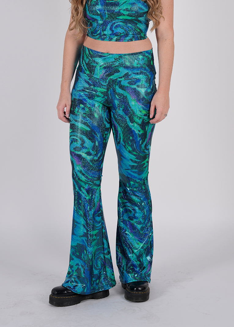 Unisex-Festival-outfit-rave-outfit - handmade-in-Brooklyn-New York City-custom made-waste conscious-groovy bellbottoms – retro style – hippie fashion – blue/green print on model  - side view- festival pants - rave pants
