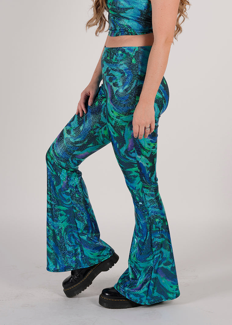 Unisex-Festival-outfit-rave-outfit - handmade-in-Brooklyn-New York City-custom made-waste conscious-groovy bellbottoms – retro style – hippie fashion – blue/green print on model - festival pants - rave pants - side view 
